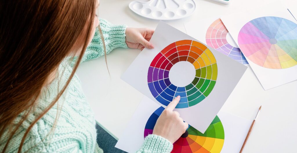 Designer working with color samples and color wheel high angle view